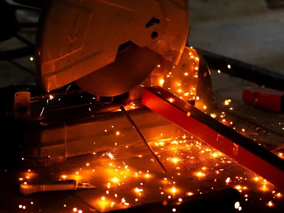 Bar stock being saw-cut to length